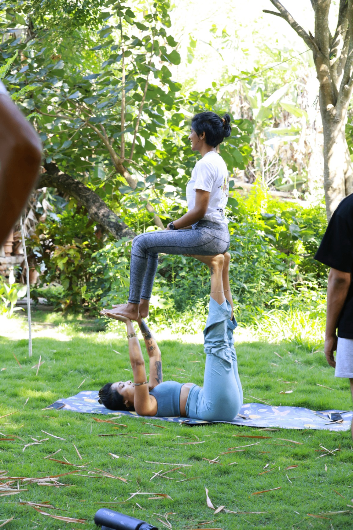 Partner acro yoga pose on the lawn